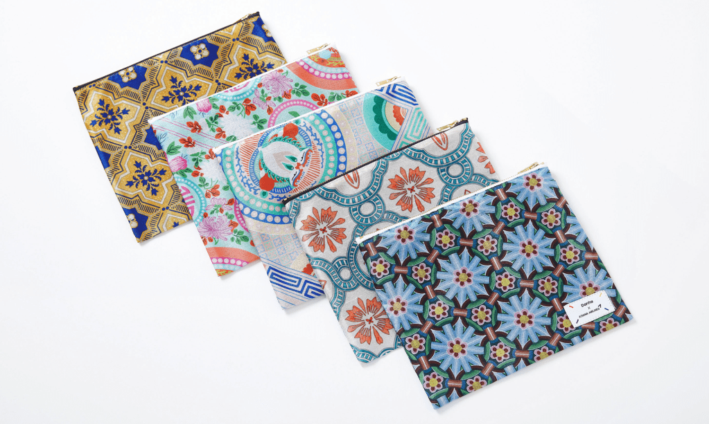 A collection of upcycled hanbok colorful patterned fabric pouches arranged in a stack, showcasing diverse designs and textures.