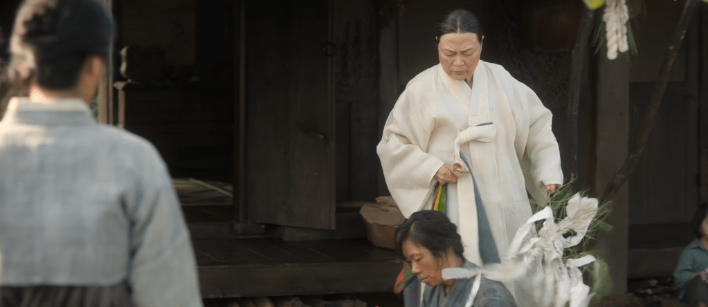 A scene from the series 'When Life Gives You Tangerines' depicting two women in one of the traditional shamanic ceremony, repelling the devil who made Aesun's mum sick