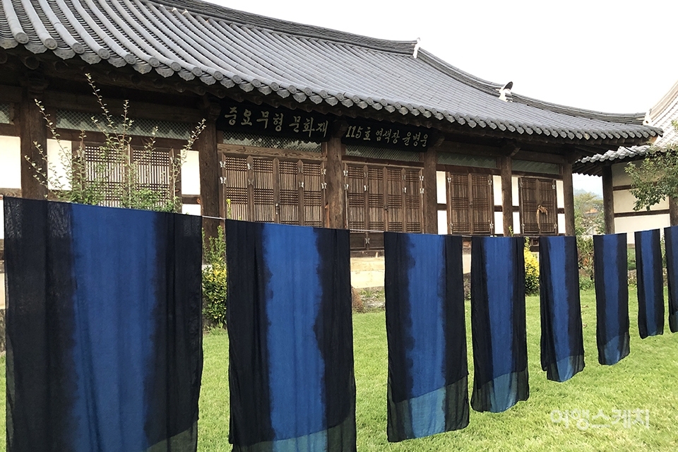 Traditional dark blue fabrics hanging outside a Jung kwan chae in Naju where Korean National intangible Cultural heritage no.115 Yoon Byeon un works, with a tiled roof and ornate eaves.