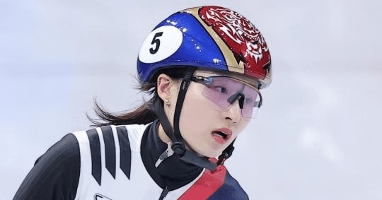 Choi Minjeong speed skater wearing a helmet with a red and blue design, protective goggles, and a racing suit, capturing the intensity of competition.
